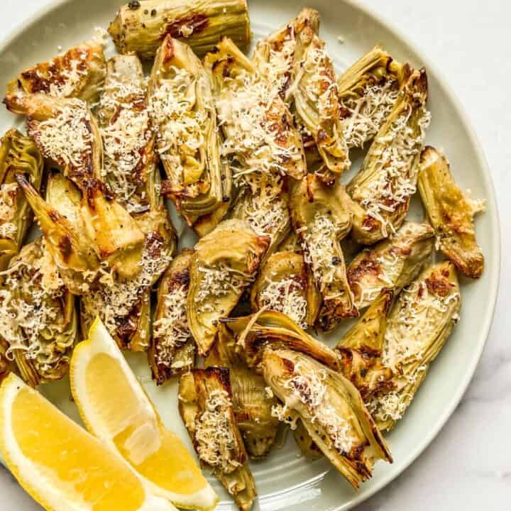 Roasted artichoke heart bites on a small plate.