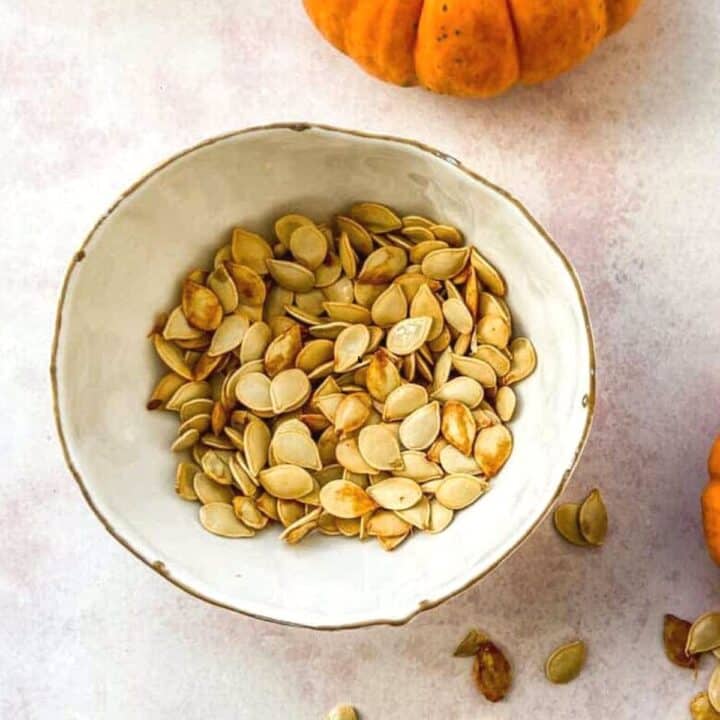 Roasted squash seeds in a small bowl.