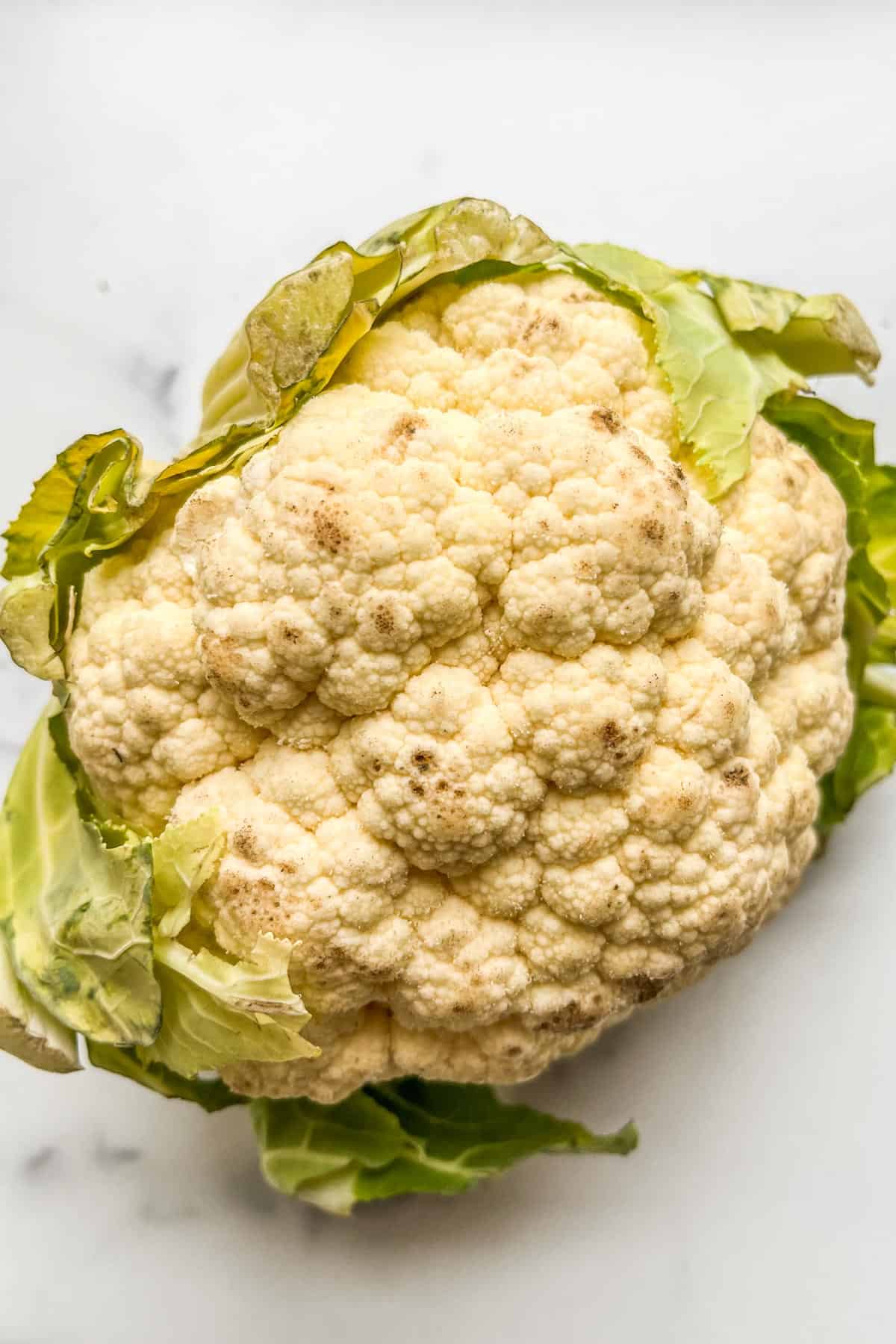 Cauliflower that has gone bad with mold and dark spots.