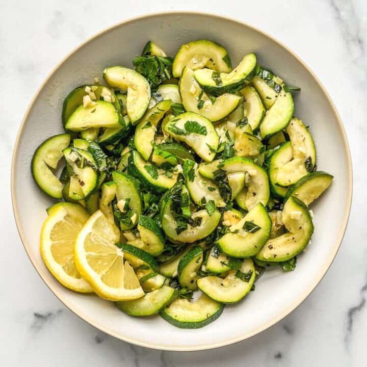 Sautéed zucchini in a white serving bowl.