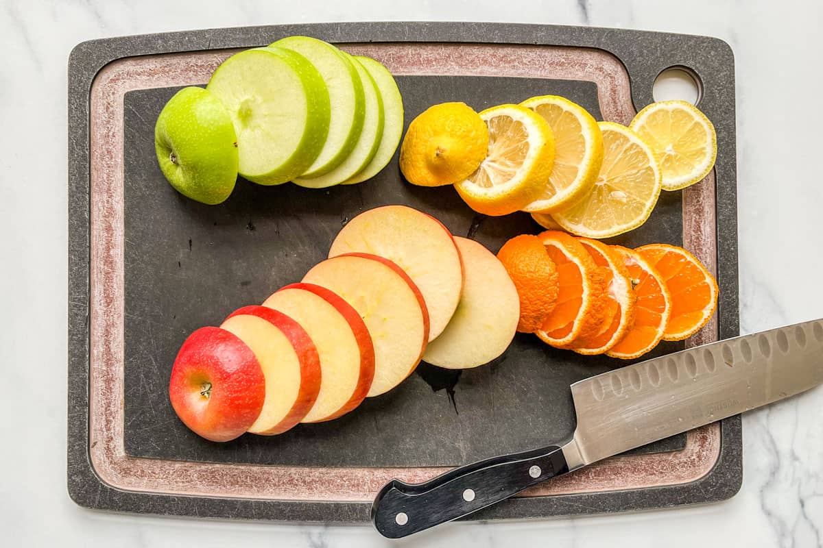 Sliced orange, lemon, green apple, and red apple.