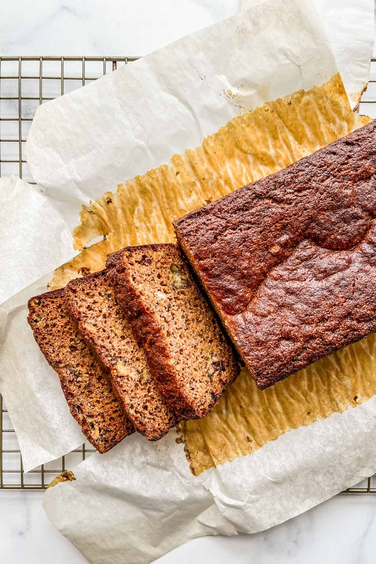 Sliced almond flour banana bread cooling a rack.