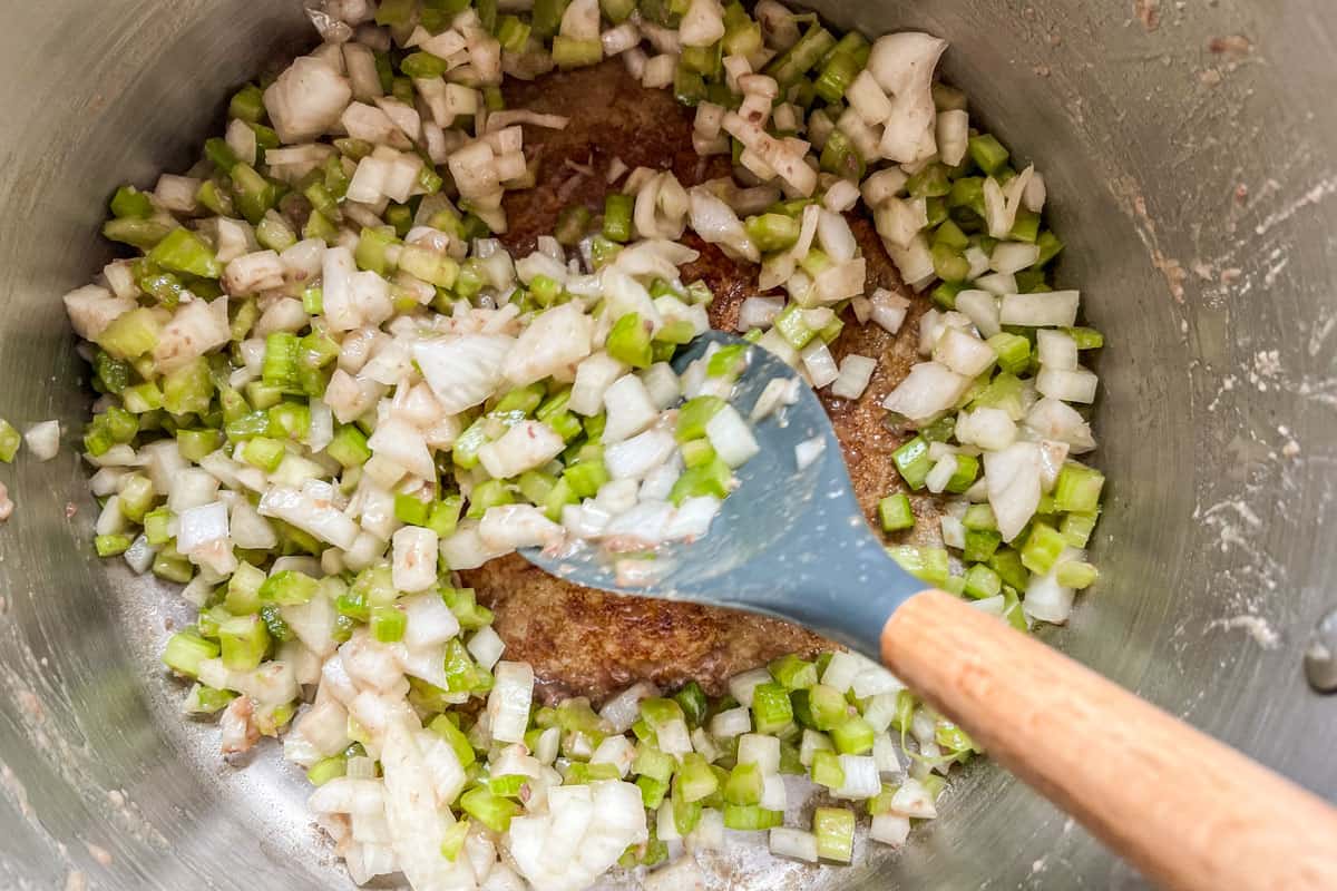 Cooking onions and celery in a pot.