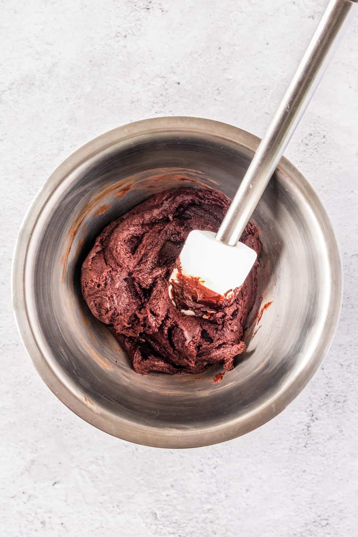 A metal mixing bowl with brownie batter.