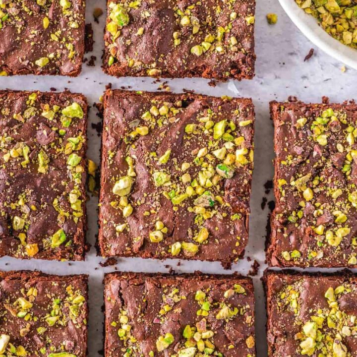 Several gluten-free brownies topped with pistachios.