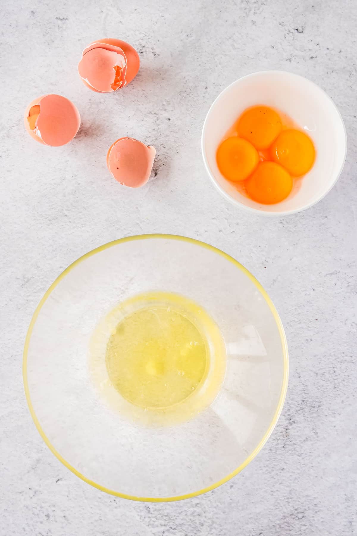 Egg yolks and whites separated in bowls.