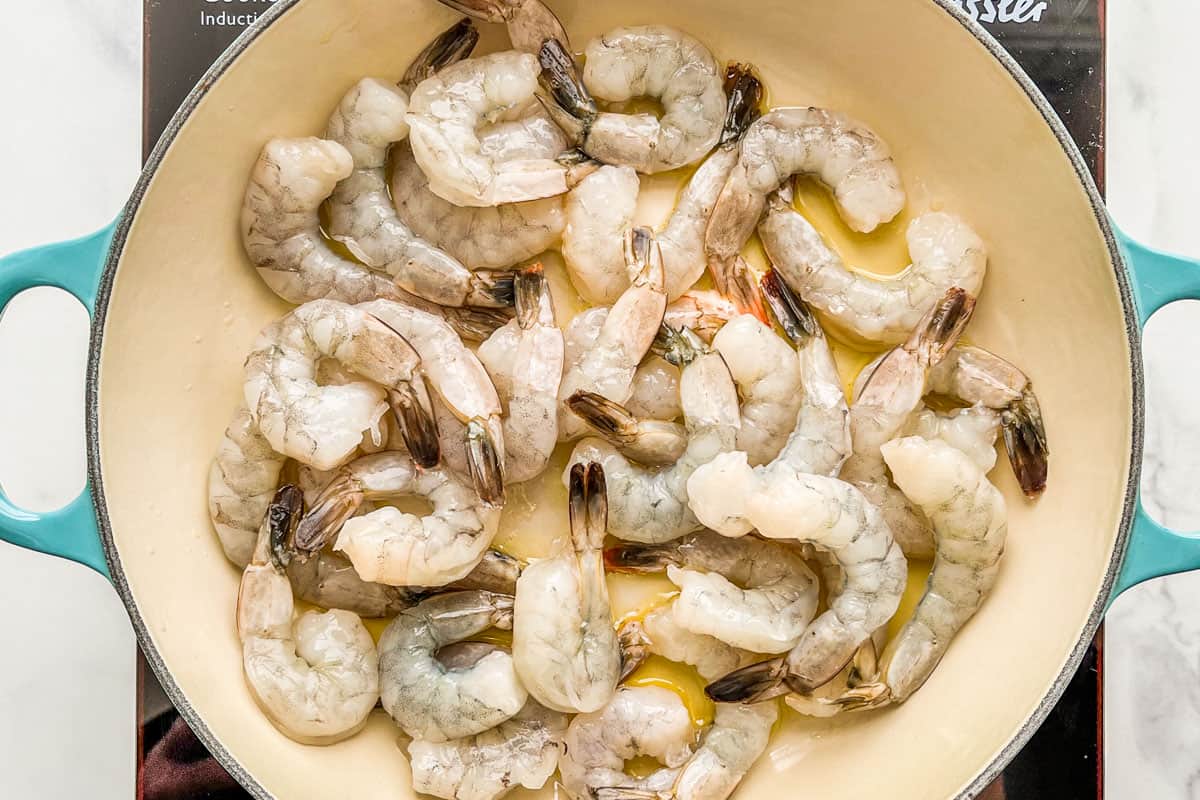 Raw shrimp in a skillet.