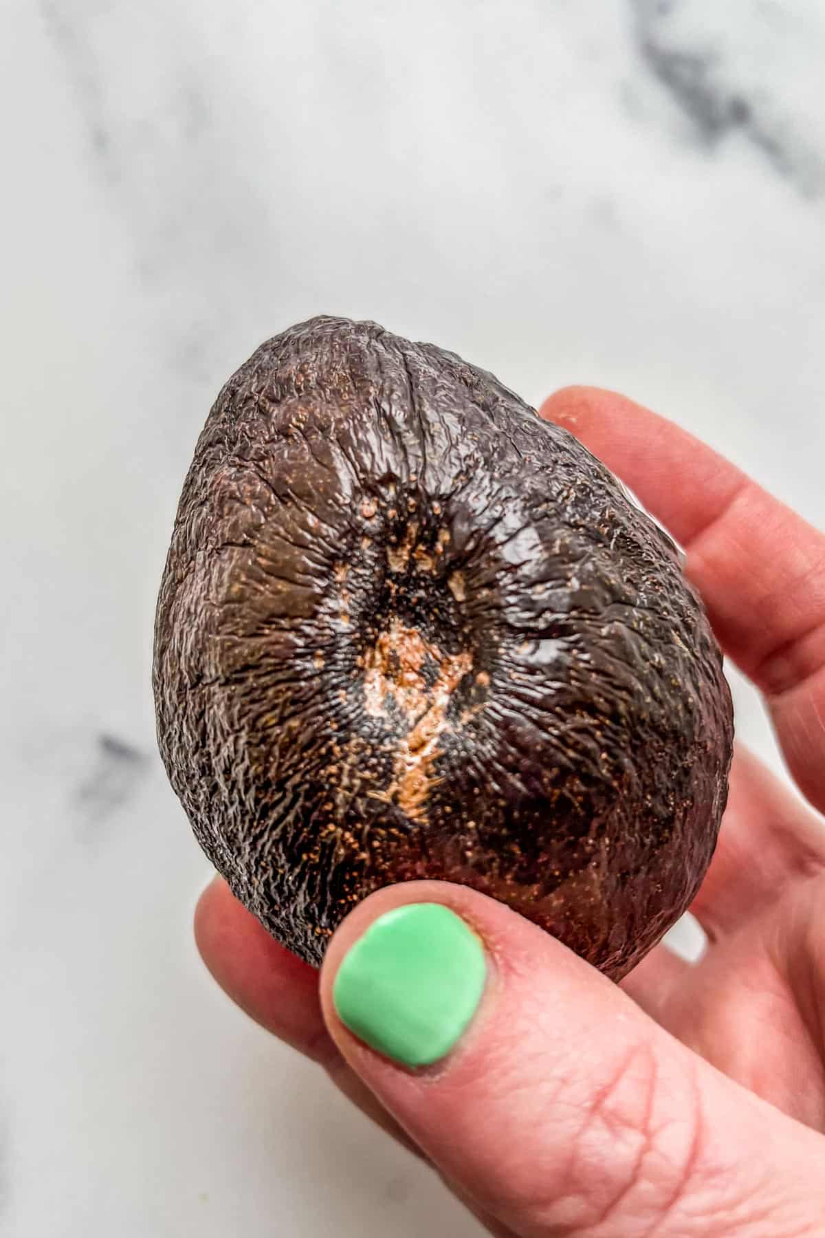 An avocado with a large divet.