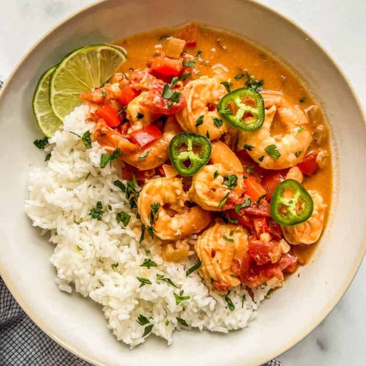 Coconut curry shrimp with rice in a white bowl.
