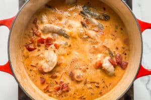 Shrimp added to the curry sauce in a pot.