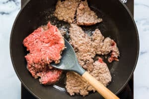 Ground beef being flipped over in a pan.