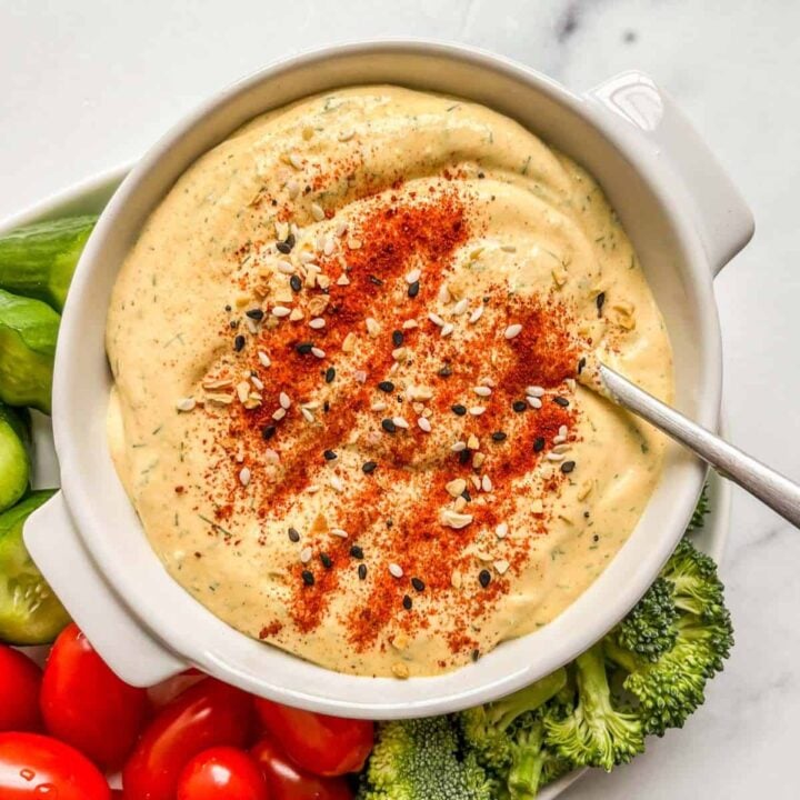 A white ramekin with a mustard cottage cheese dip.