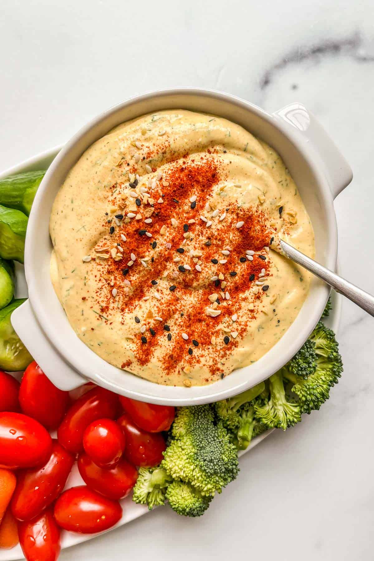 Cottage cheese and mustard dip in a ramekin topped with bagel seasoning and paprika.