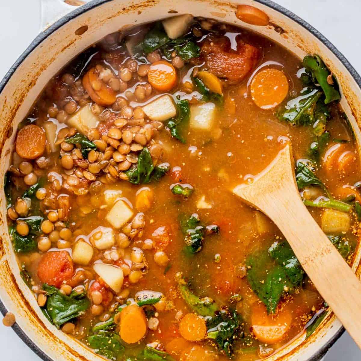 A large pot of lentil soup with potatoes and carrots.