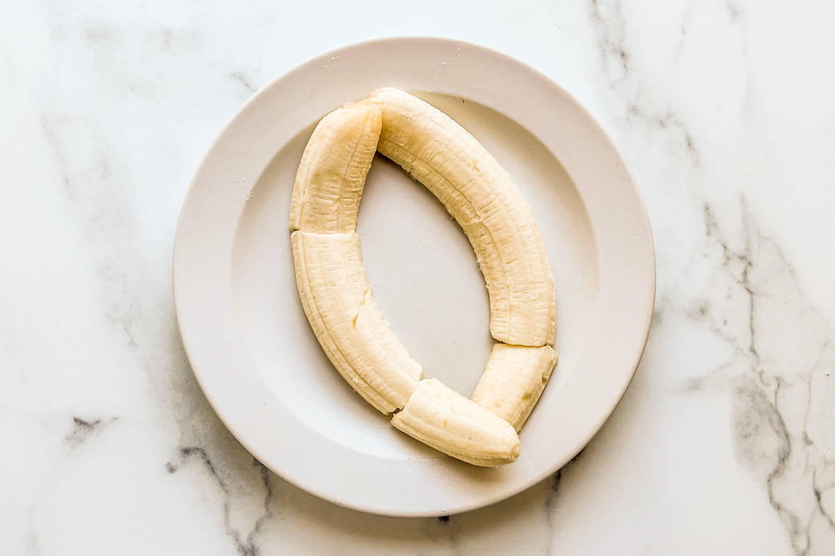 A halved banana on a plate.
