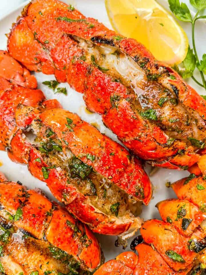 Grilled lobster tails on a white plate.