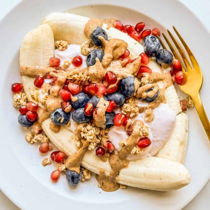 A healthy banana split with yogurt, granola, and berries.