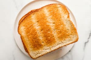 Toasted bread on a white plate.
