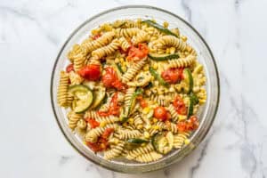 Pesto pasta salad in a glass bowl.