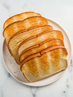 Toasted bread on a white plate.