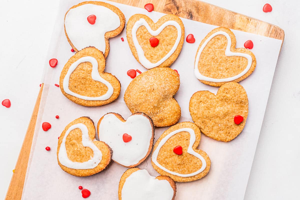 Heart sugar cookies on a cutting board.