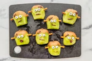 Eight kiwi frankensteins assembled on a cutting board.