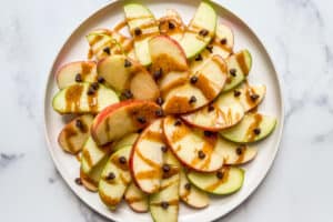 Apple slices drizzled with vegan caramel sauce and mini chocolate chips.