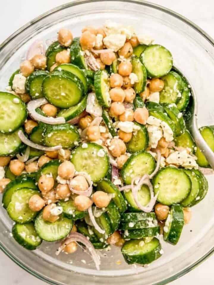 A cucumber chickpea salad in a glass bowl.