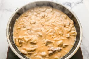Simmering the mushroom sauce in a frying pan.