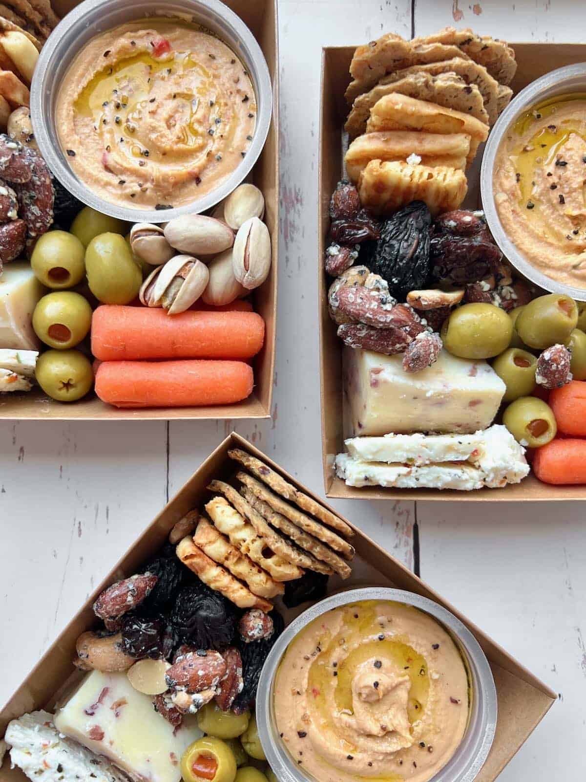 Three individual charcuterie boxes.