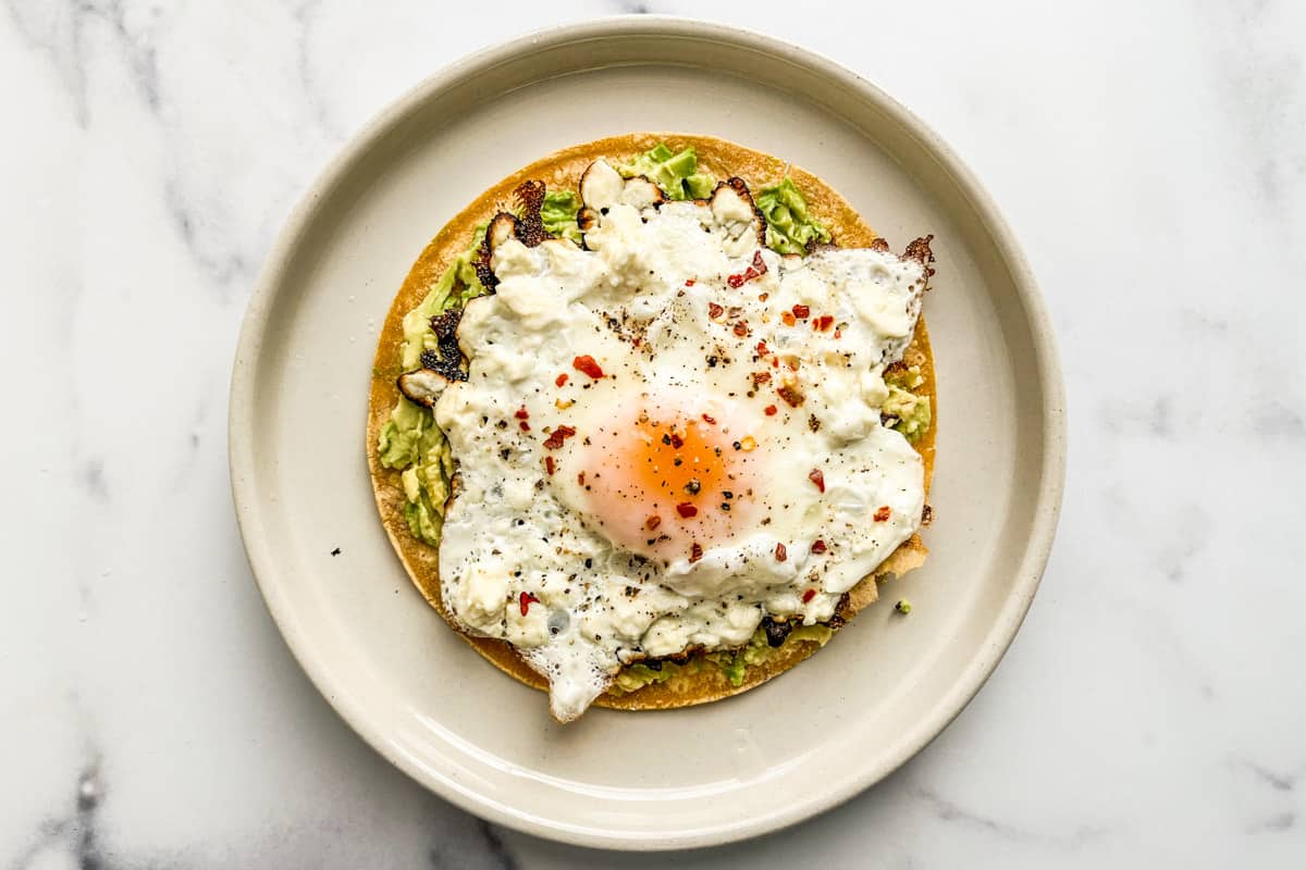 A feta egg on a toasted tortilla with avocado.