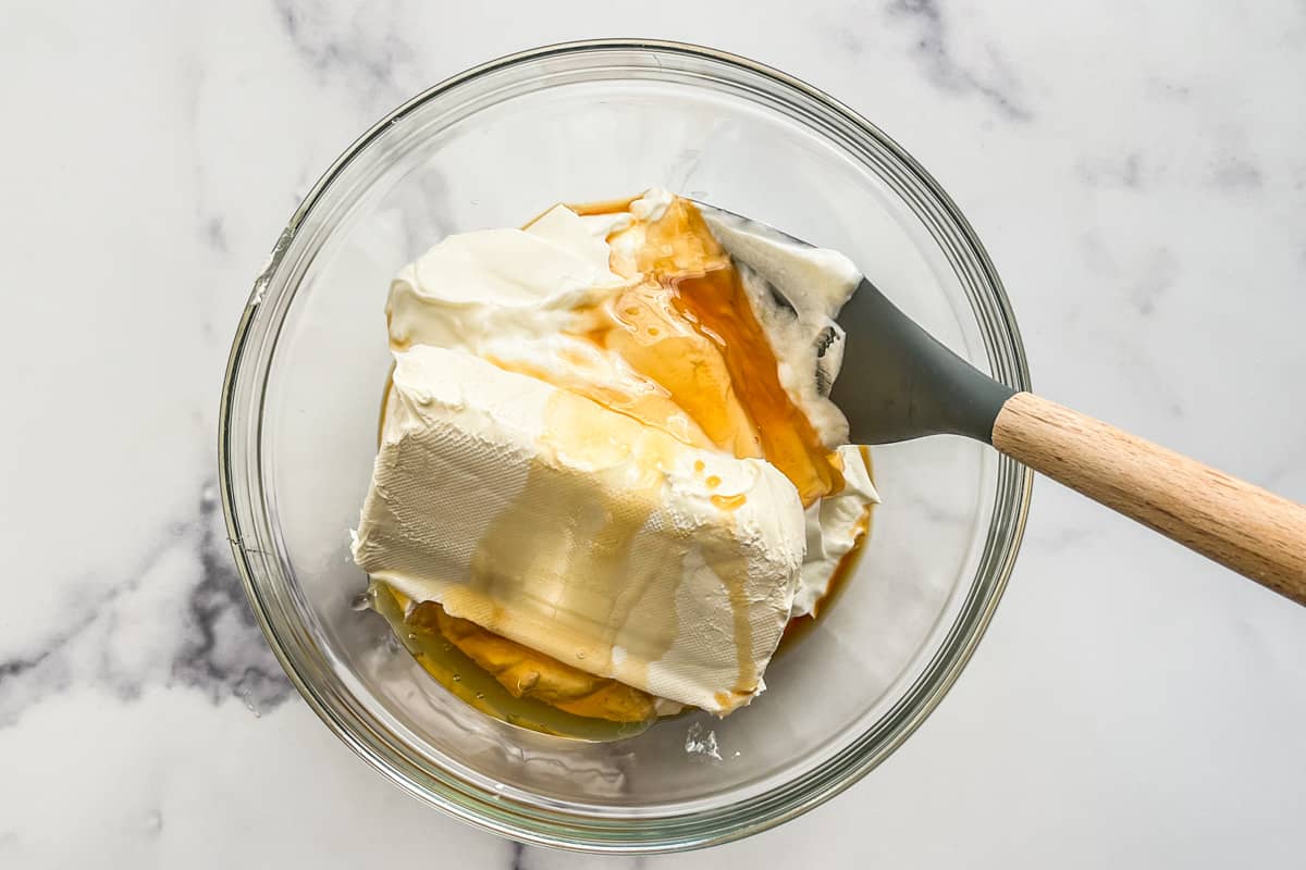 Greek yogurt, cream cheese, honey, and vanilla in a glass bowl.