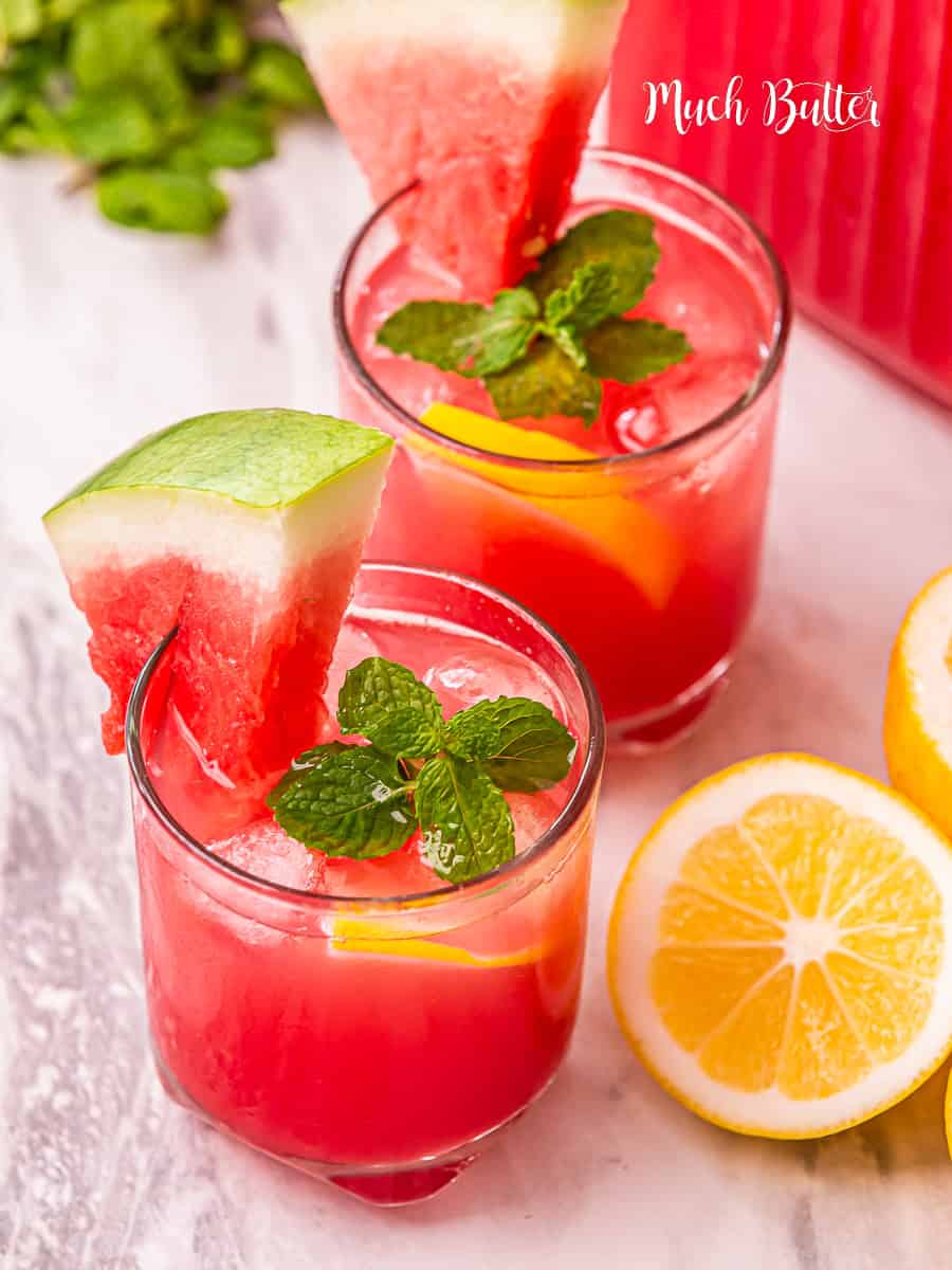 Two glasses of watermelon lemonade with slices of watermelon and mint.