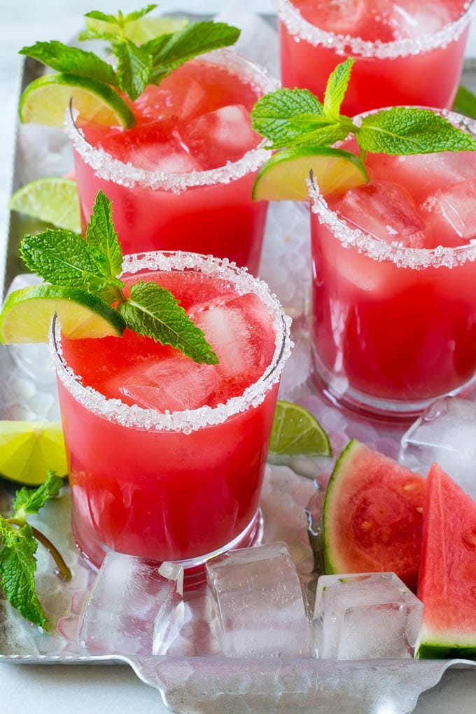 Four glasses on watermelon agua fresca on a tray with ice.