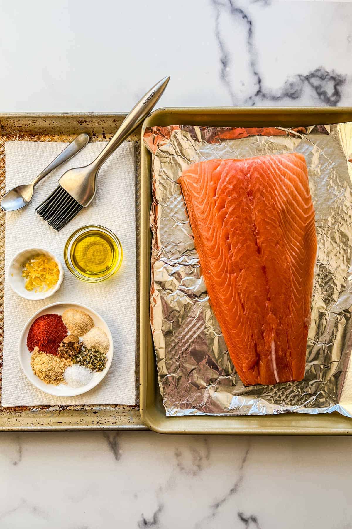 Ingredients for broiled salmon on a rimmed baking sheet.