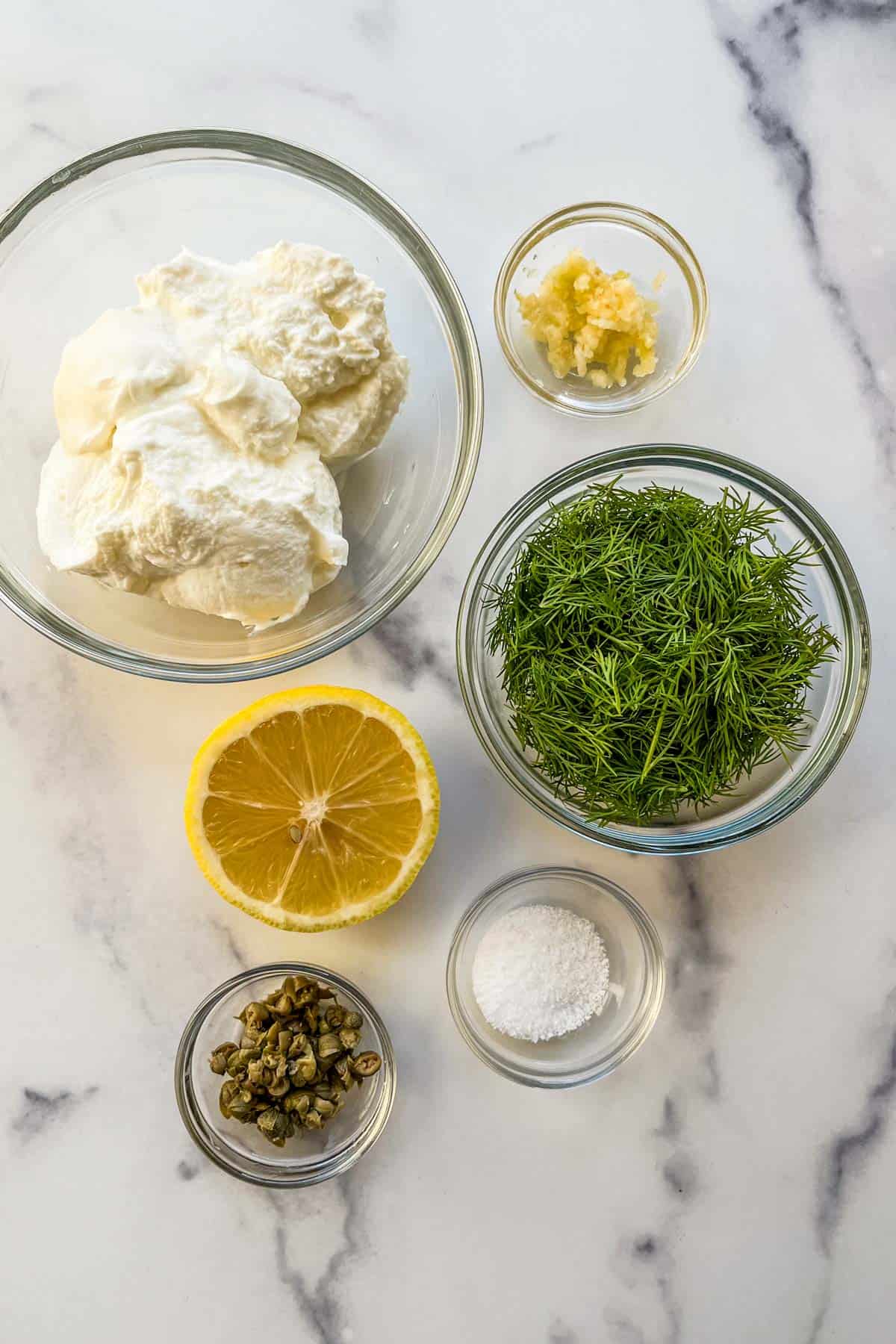 Ingredients for dill sauce in glass bowls.
