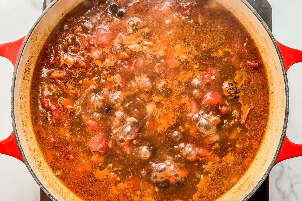 Ground beef chili simmering in a dutch oven.