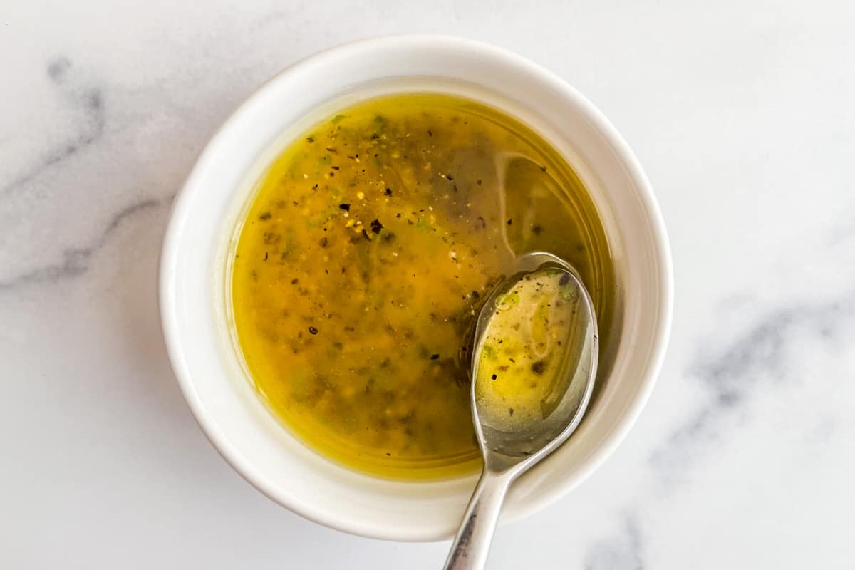 Honey citrus salad dressing being mixed in a small bowl.