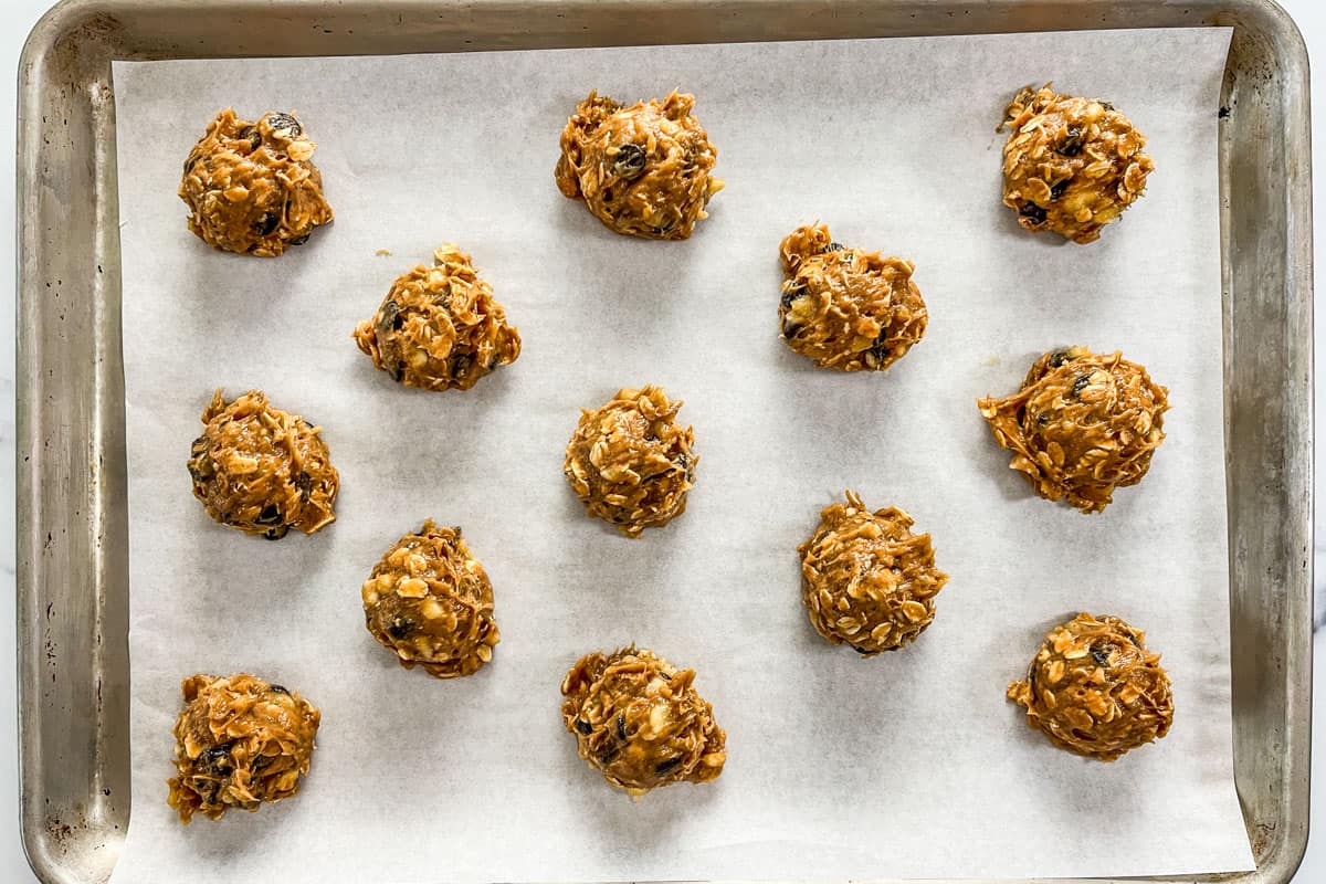 Banana cookie dough balls on a parchment lined baking sheet.