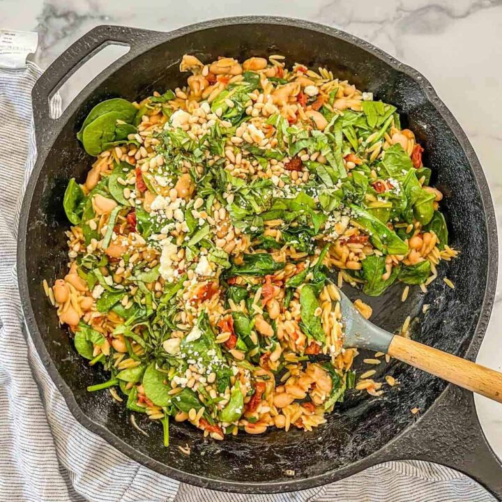 One pot orzo and white beans in a skillet.