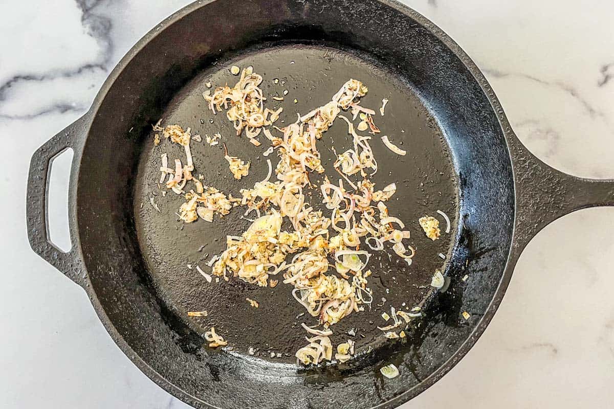 Shallots and garlic cooking in a skillet.