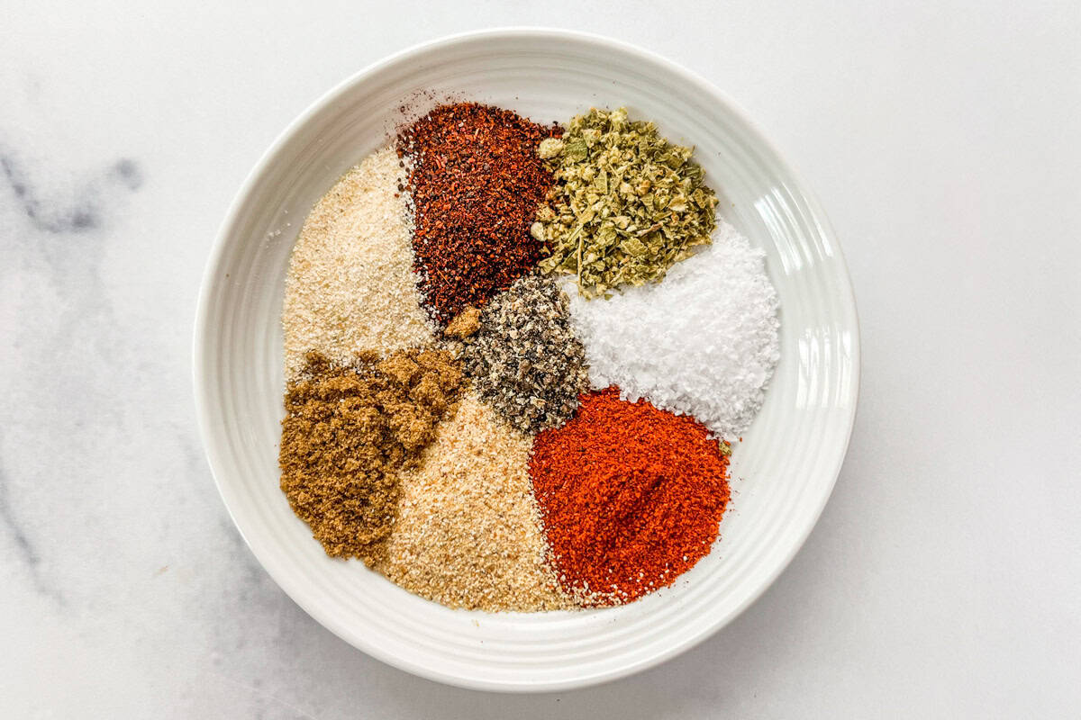 Spices for steak taco seasoning blend on a small white plate.