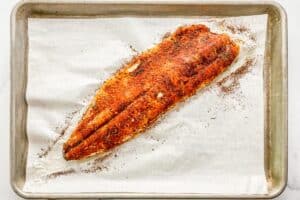 A large piece of trout baked on a sheet pan.