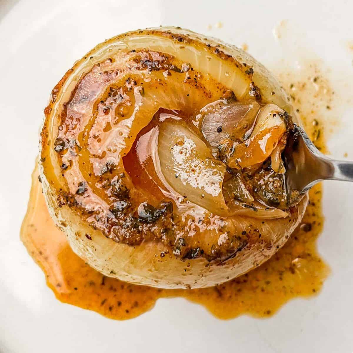 An onion boil topped with spices and butter on a white plate.