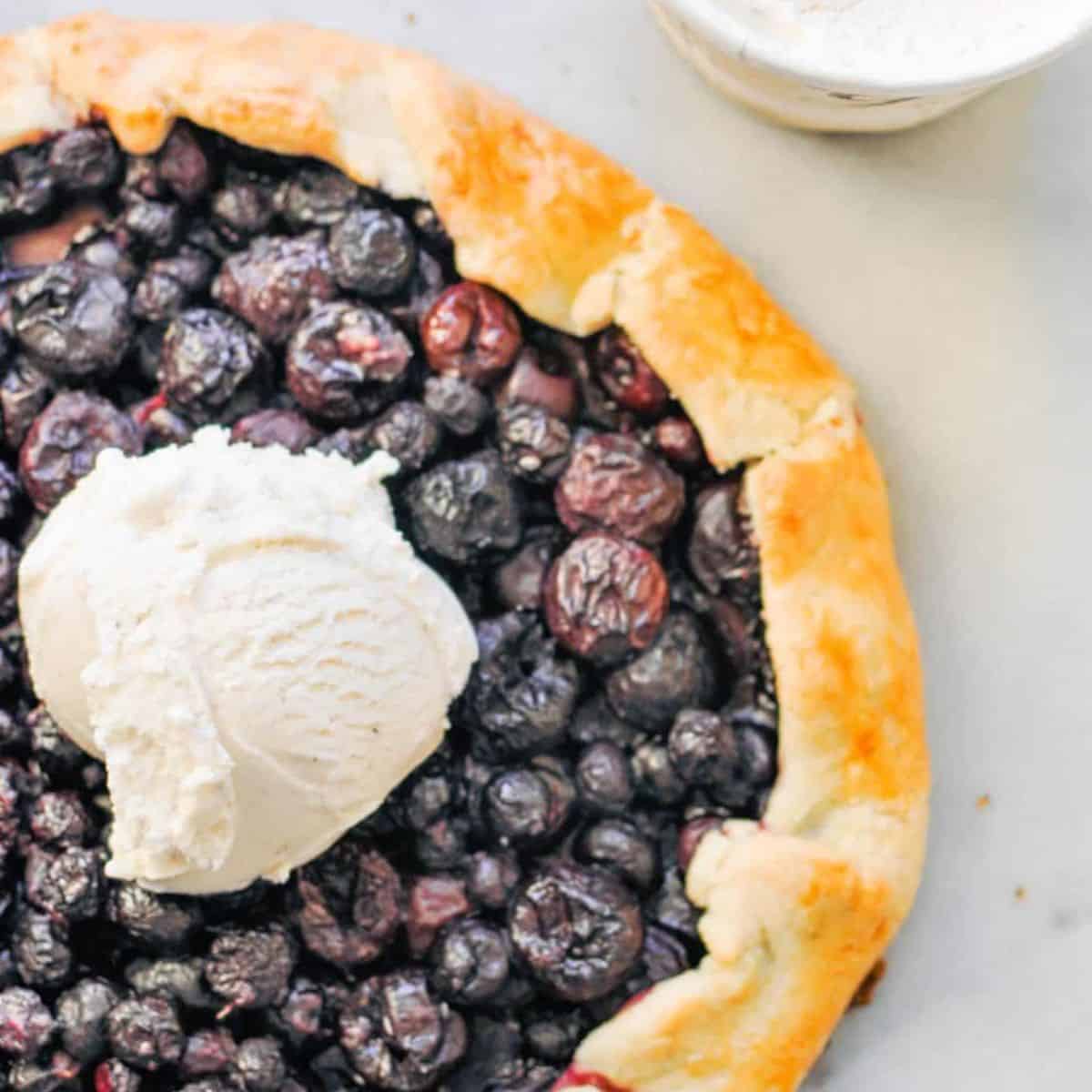 Cherry blueberry galette topped with vanilla ice cream.