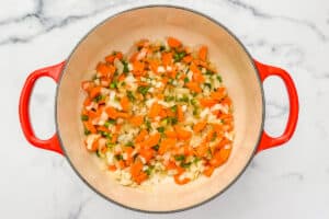 Carrots, onions, and jalapeno cooking in a pot.