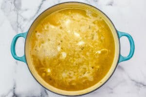 Stock, chickpeas, onions, and spices in a skillet.