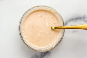 Mayo hot sauce in a small glass bowl with a gold spoon.