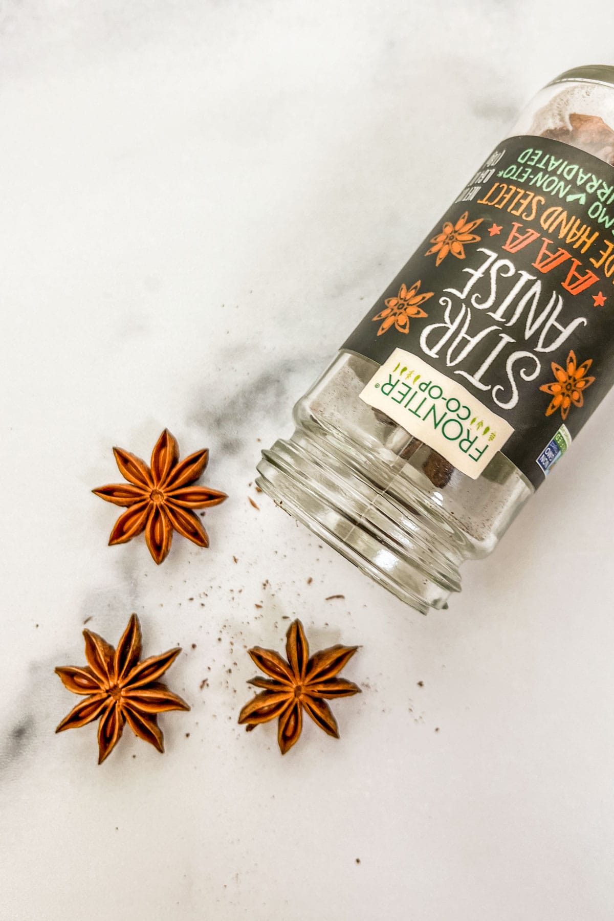 Star anise coming out of a glass jar.