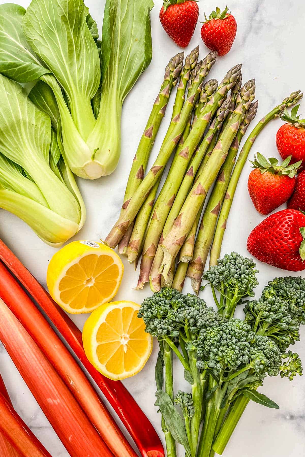 Bok choy, asparagus, strawberries, baby broccoli, lemon, and rhubarb.